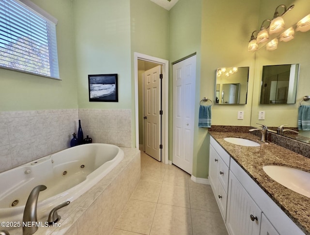 full bath featuring double vanity, a tub with jets, a sink, and tile patterned floors