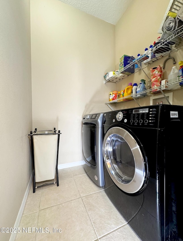 laundry area with laundry area, baseboards, a textured ceiling, separate washer and dryer, and light tile patterned flooring