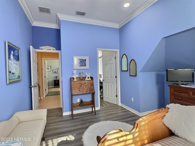 bedroom featuring visible vents, crown molding, and wood finished floors