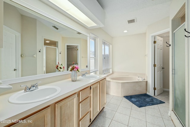 bathroom featuring a stall shower, tile patterned flooring, a sink, and visible vents