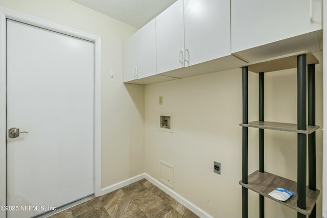 clothes washing area with cabinet space, baseboards, hookup for a washing machine, hookup for an electric dryer, and a textured ceiling