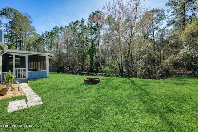 view of yard with a sunroom and an outdoor fire pit