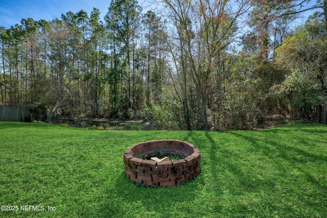 view of yard featuring an outdoor fire pit and fence