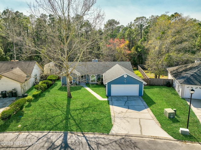 ranch-style home with a garage, a shingled roof, fence, driveway, and a front yard