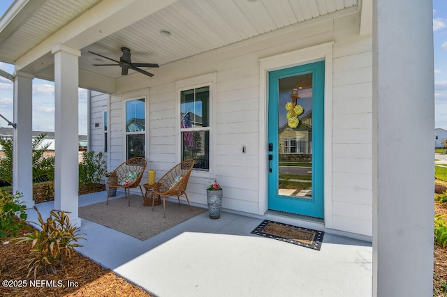 entrance to property with ceiling fan and a porch