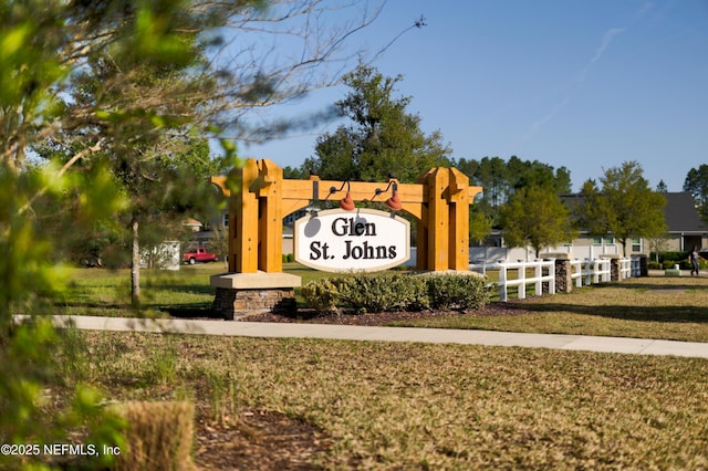 community sign featuring fence and a yard