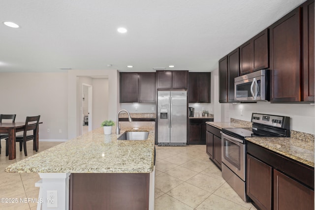 kitchen featuring a sink, light tile patterned floors, dark brown cabinets, and stainless steel appliances