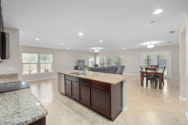 kitchen featuring a sink, appliances with stainless steel finishes, light tile patterned floors, and open floor plan