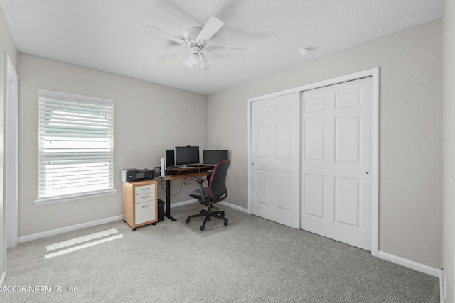 carpeted office with a ceiling fan and baseboards