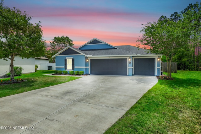 ranch-style house with an attached garage, fence, a front yard, and concrete driveway