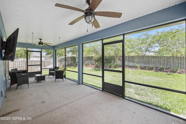 unfurnished sunroom featuring ceiling fan