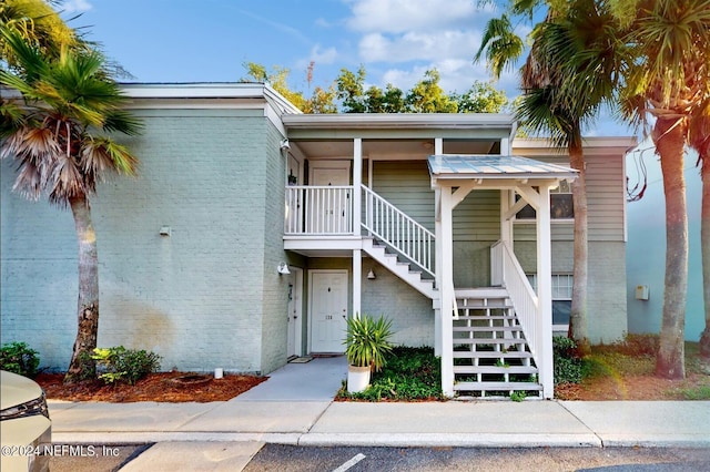 view of front of house with stairs and brick siding