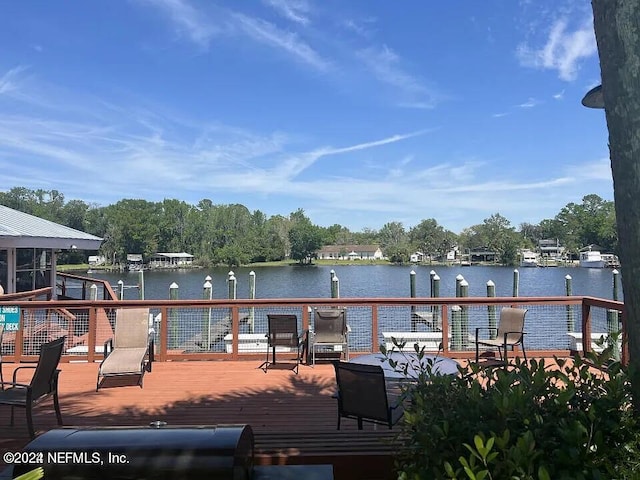 wooden terrace featuring a boat dock and a water view