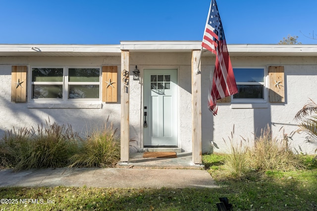 entrance to property featuring stucco siding