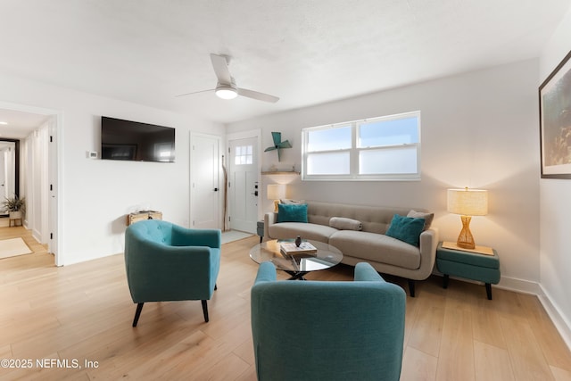 living room with light wood-style floors, baseboards, and a ceiling fan