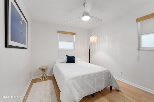 bedroom with a ceiling fan, baseboards, and wood finished floors