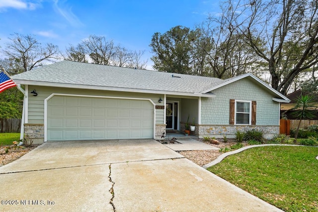 view of front of house featuring stone siding, driveway, a garage, and fence