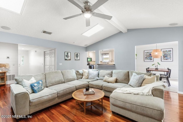 living room with visible vents, a textured ceiling, lofted ceiling with beams, and dark wood-style flooring