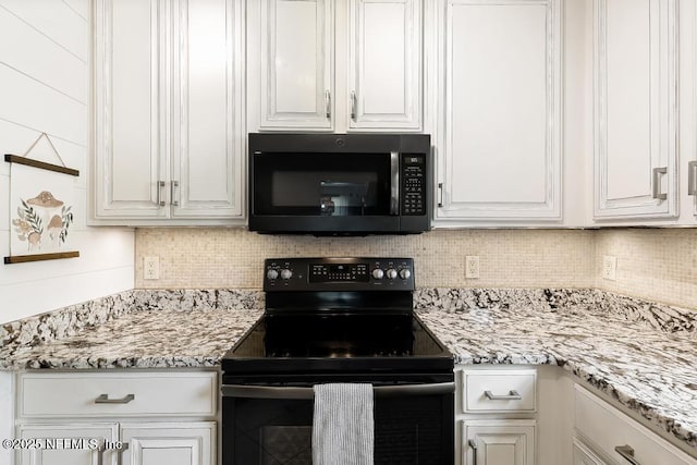 kitchen featuring tasteful backsplash, white cabinetry, black range with electric stovetop, and light stone counters