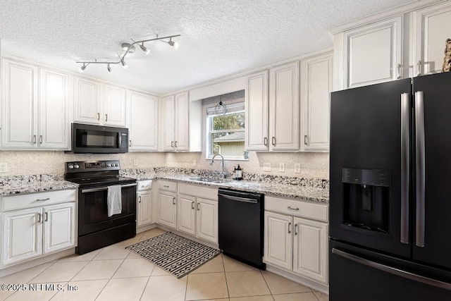 kitchen featuring a sink, backsplash, black appliances, and light tile patterned flooring