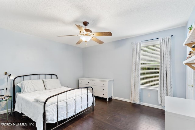 bedroom featuring a ceiling fan, wood finished floors, baseboards, and a textured ceiling