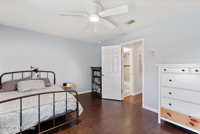 bedroom featuring visible vents, a textured ceiling, baseboards, and wood finished floors