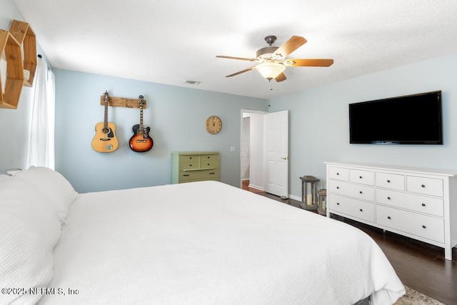 bedroom with dark wood finished floors, visible vents, and a ceiling fan