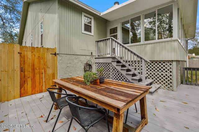 wooden terrace with outdoor dining area and fence