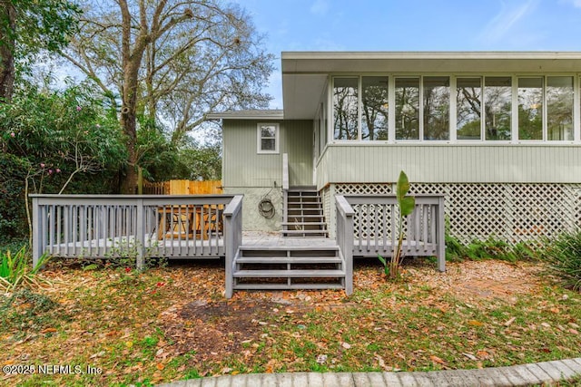 rear view of property featuring a deck and fence