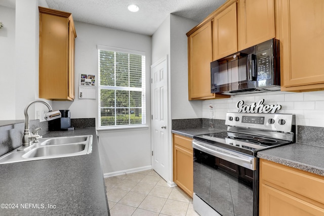 kitchen featuring black microwave, a textured ceiling, a sink, dark countertops, and stainless steel range with electric stovetop