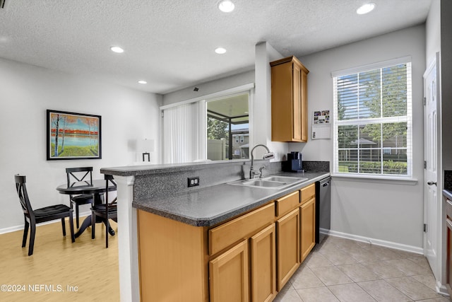 kitchen featuring dark countertops, recessed lighting, a sink, dishwasher, and a peninsula