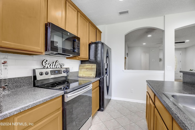 kitchen featuring tasteful backsplash, visible vents, stainless steel electric stove, black microwave, and a sink