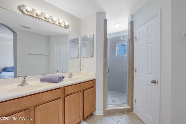 ensuite bathroom with a stall shower, a sink, visible vents, and tile patterned floors