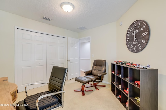 carpeted office space with a textured ceiling and visible vents