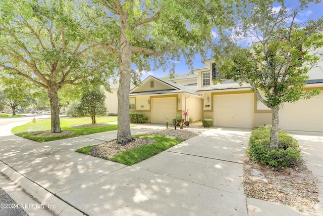 view of front of home with driveway, a garage, and stucco siding