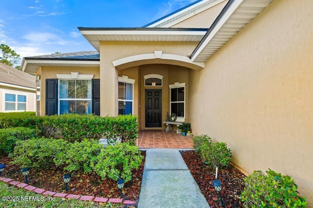 view of exterior entry with stucco siding