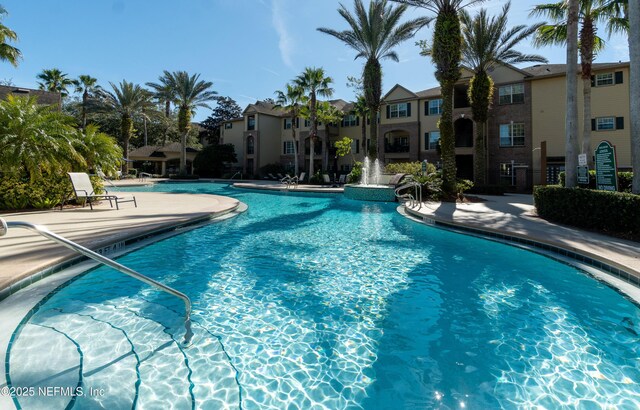 pool with a residential view and a patio