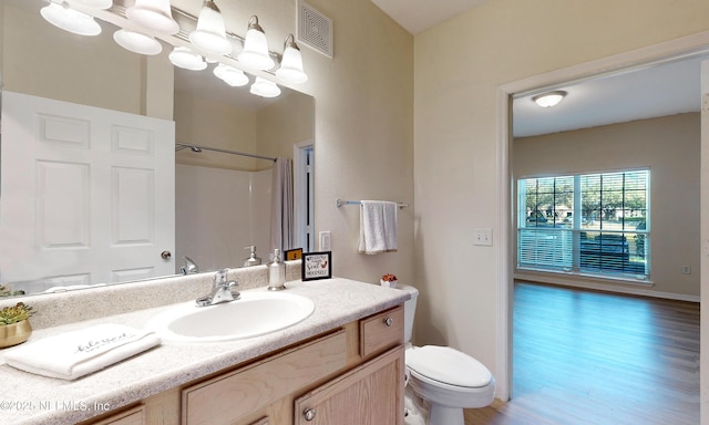 full bathroom with visible vents, toilet, wood finished floors, vanity, and a notable chandelier