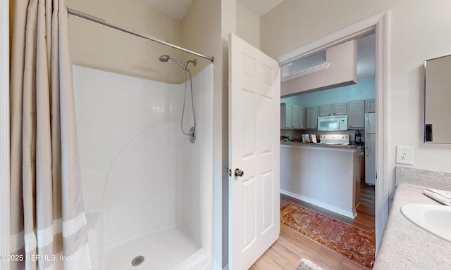 full bathroom featuring vanity, a shower with shower curtain, and wood finished floors