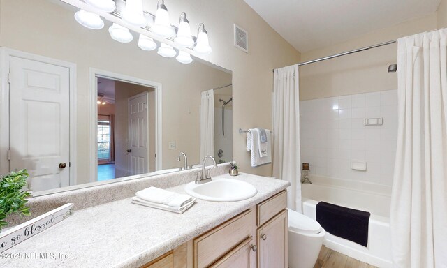 bathroom with toilet, vanity, visible vents, and shower / tub combo with curtain