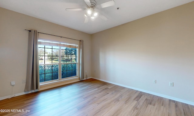 empty room with a ceiling fan, light wood-style flooring, and baseboards