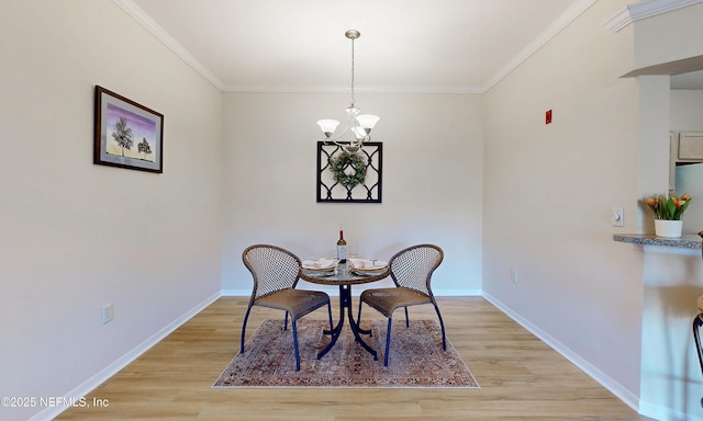 dining room featuring a chandelier, light wood-type flooring, and baseboards