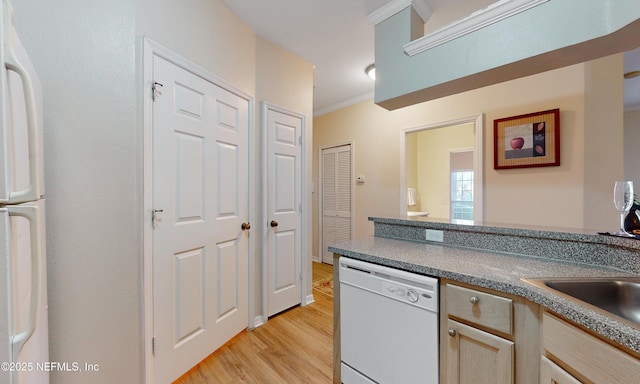 kitchen with white appliances, ornamental molding, and light wood finished floors