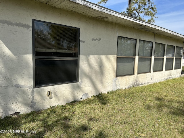 view of home's exterior featuring stucco siding and a lawn