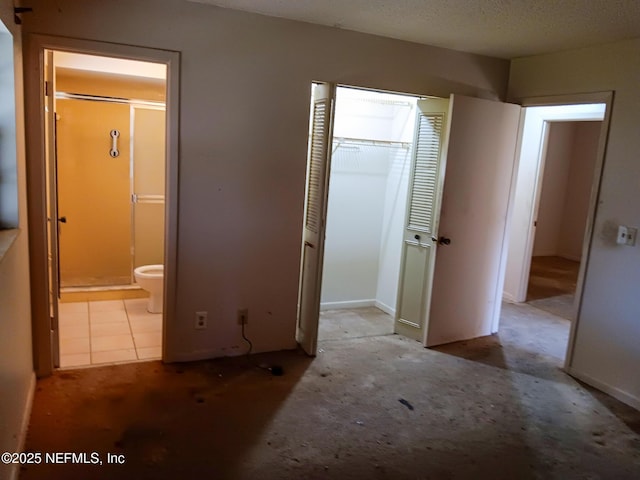 unfurnished bedroom with a closet and ensuite bathroom