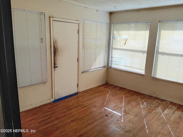 spare room featuring a textured ceiling and wood finished floors