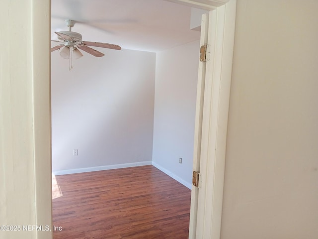 unfurnished room featuring wood finished floors, baseboards, and ceiling fan