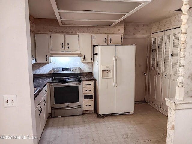 kitchen with under cabinet range hood, dark countertops, white refrigerator with ice dispenser, stainless steel electric range, and light floors