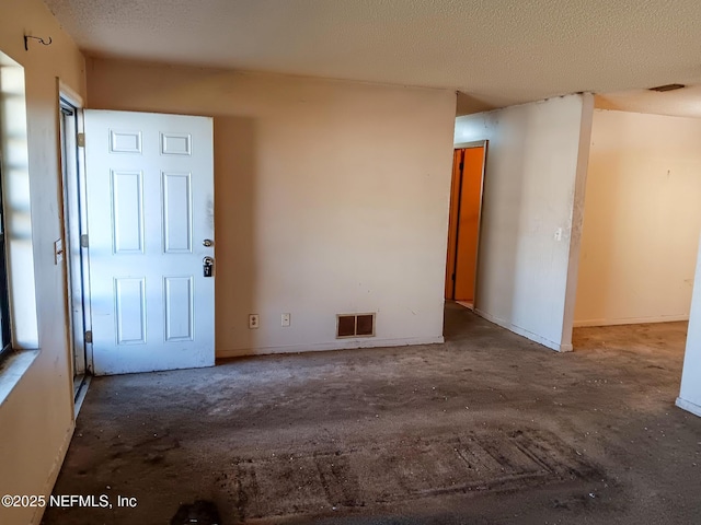 unfurnished room featuring visible vents and a textured ceiling