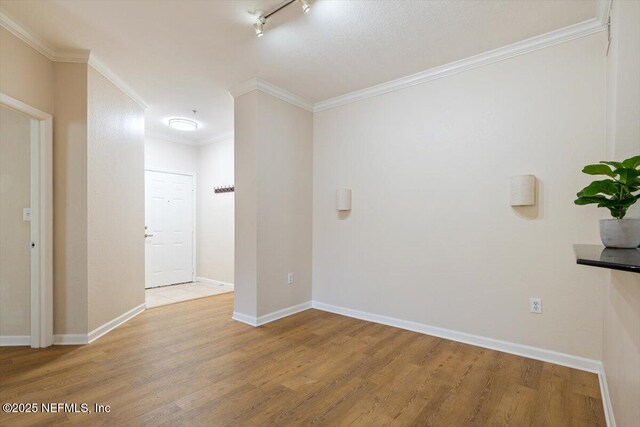 8539 Gate Pkwy W Unit 1723, Jacksonville, FL 32216 - empty room with track lighting, ornamental molding, baseboards, and wood finished floors